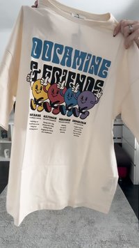 Kreemi värvi puuvillane T-särk, millel on julge graafika värvikate, koomiliste tegelaste ja tekstiga neurotransmitterite ning nende toimete kohta.