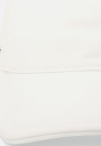 White baseball cap with a textured fabric, curved brim, and visible stitching along the edge. Simple design, no additional embellishments.