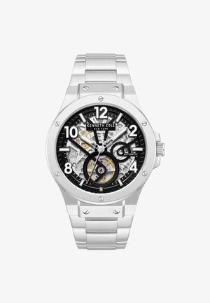 Orologio da polso automatico Kenneth Cole argento con quadrante nero e trasparente che mostra gli ingranaggi interni, indici delle ore argentati e cinturino a maglie in metallo.