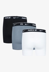 Tri pares kratkih bokseric Nike v črni, sivi in beli barvi z črnim elastičnim pasom, ki nosi bel Nike logotip.