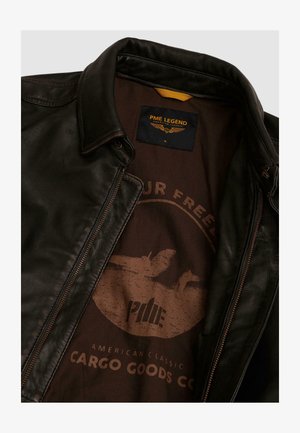 Schwarze Lederjacke mit braunem Innenfutter, das eine runde Grafik und den Text "PME Legend American Classic Cargo Goods Co." zeigt