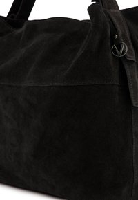 Zwarte suède handtas met een zachte textuur, rechthoekige vorm en gepolijste hardwareaccenten. Naaddetails lopen over de voorkant.