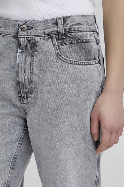 Jean en denim gris avec un effet délavé, dotés d'une fermeture à bouton en métal, de passants de ceinture et d'une poche latérale. La texture est lisse et robuste.