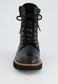 Bottes en cuir noir à lacets avec un col en polaire noir texturé, une semelle en caoutchouc robuste et des coutures contrastantes en tan le long du bord.