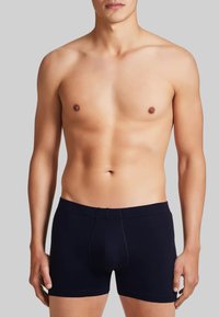 Boxer briefs neri con un design aderente, vita elastica e dettagli di cucitura sottili. Tessuto liscio con branding minimale.