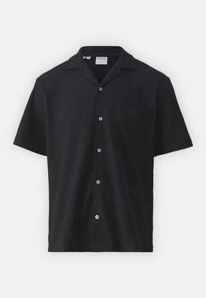 Kortermet svart skjorte laget av teksturert stoff med et subtilt ribbestrikket mønster, med knappefront og lomme på brystet.