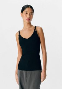 Top de tirantes negro de canalé con escote en V, que presenta tirantes retorcidos y detalles metálicos. Silueta ajustada con una tela texturizada.