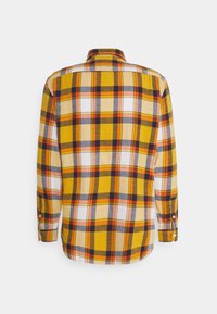 Camicia gialla a scacchi con maniche lunghe, caratterizzata da quadretti arancioni, grigi e bianchi, con chiusura a bottoni e un design con colletto classico.