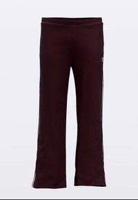 Tumši sarkanas sporta bikses ar taisnu griezumu, ar baltām sānu svītrām un redzāmām šuvju detaļām. Izgatavotas no elastīga, mīksta auduma.