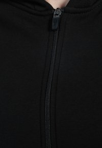 Czarna bluza z kapturem zapinana na zamek, wykonana z miękkiej bawełny. Posiada solidny zamek z teksturowanym uchwytem oraz prosty, minimalistyczny design.