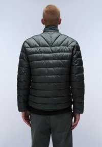 Mörkgrön puffjacka med horisontella quiltade sektioner, hög krage och en stilren, slät yta. Lättviktig design för värme.