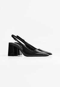 Musta patentoitu nahka slingback-korkokengät, joissa on terävä kärki ja tukeva lohkokorko. Varustettu ohuella säädettävällä hihnalla ja metallisoljella.
