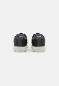 Schwarze Ledersneaker mit weißen Gummisohlen, ausgestattet mit einem strukturierten Fersenpatch und "Levi's"-Branding in Weiß auf der Rückseite.