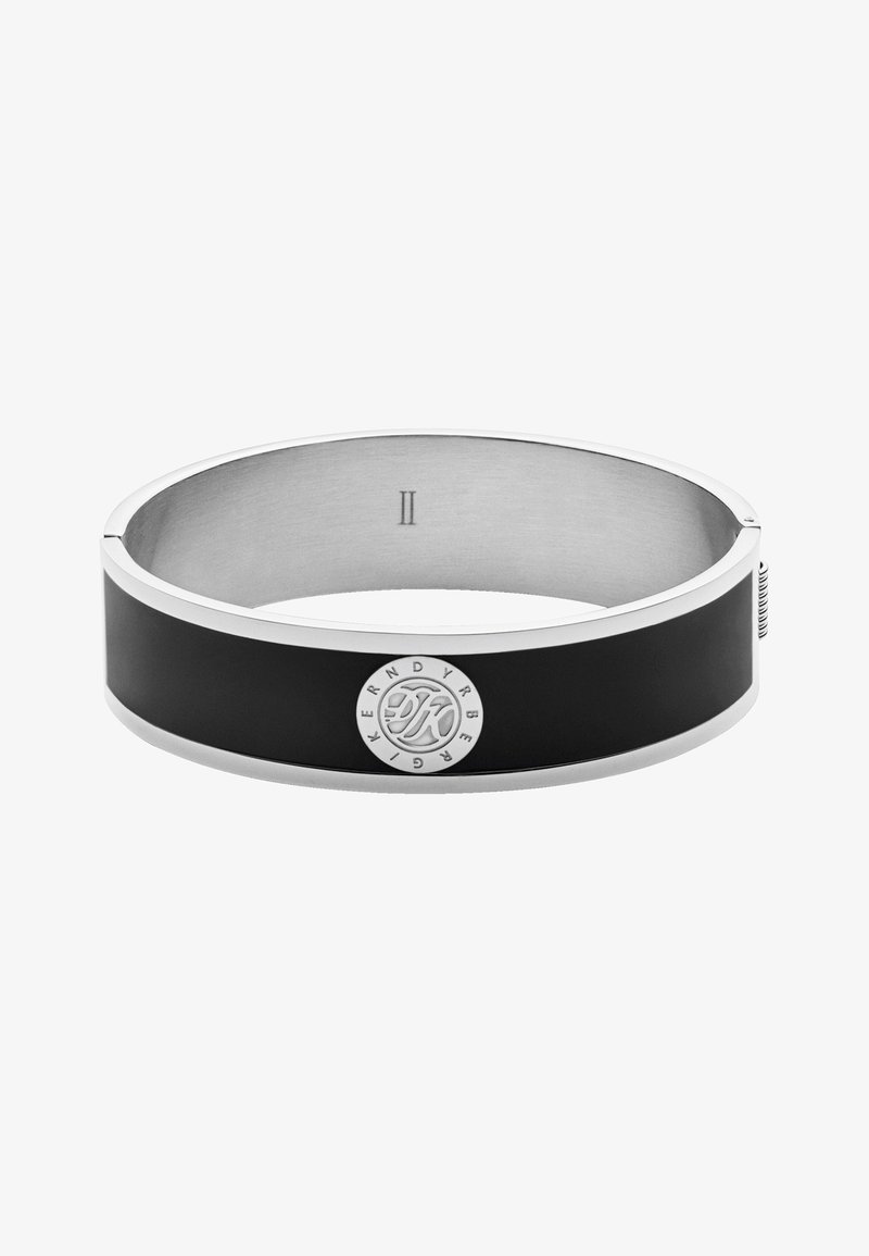 Bracelet jonc en métal argenté et noir avec une plaque circulaire gravée du logo "Kern Dyrberg" autour des initiales "KD".