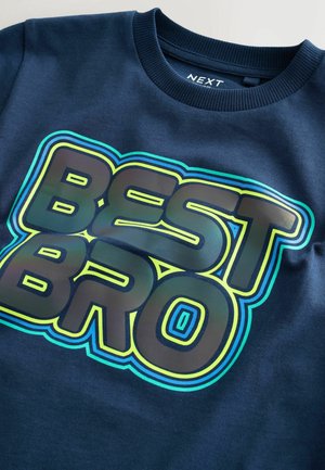 Navy Sweatshirt mit einem großen, mehrfarbigen "BEST BRO"-Graphic mit glanzvollem Finish und geschichteten Umrandungen auf einem strukturierten Stoff.