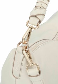 Hellbeige Handtasche mit einer strukturierten Lederoberfläche. Goldfarbene Beschläge einschließlich Federclips und einem geflochtenen Schultergurt.