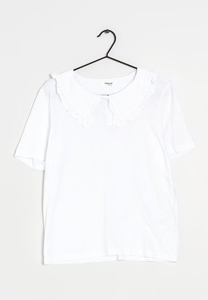 White short-sleeve blouse with a large, ruffled Peter Pan collar on a black hanger against a plain light background.
