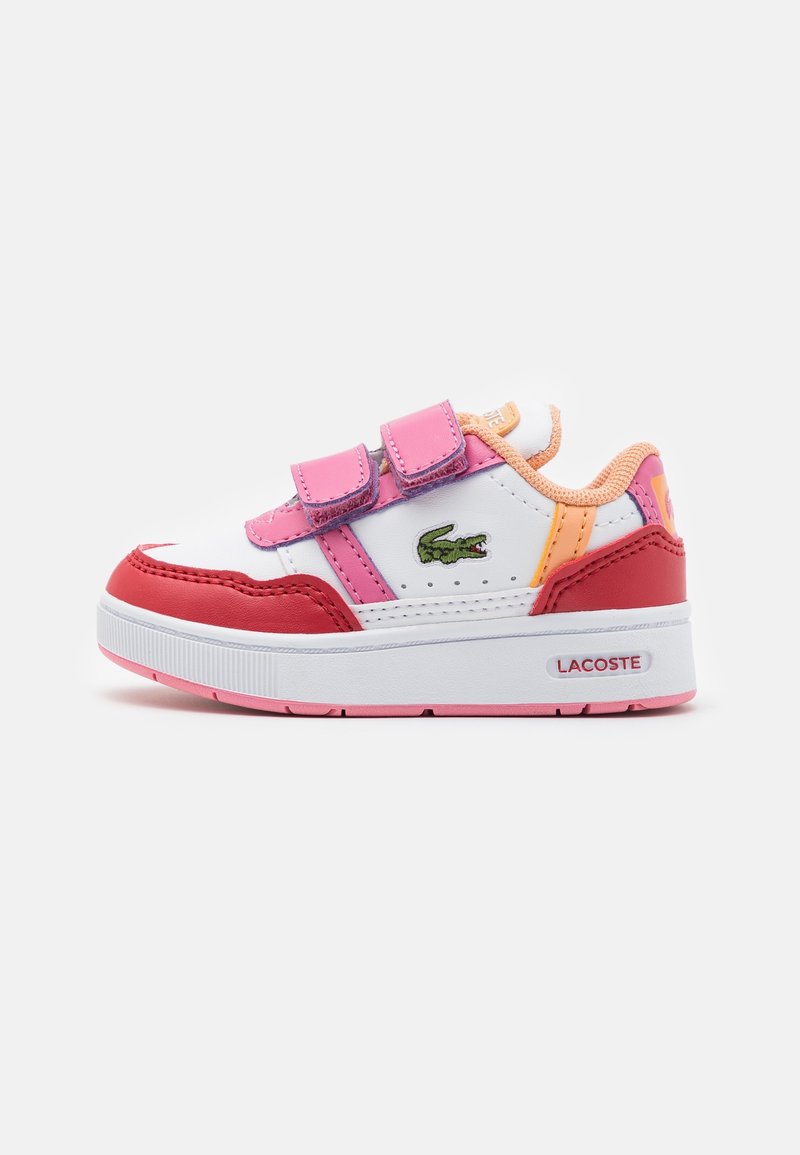 Baskets blanches pour enfants avec des accents rose, rouge et orange, deux bandes velcro roses et un logo crocodile vert sur le côté.
