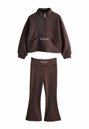 Braunes, kurz geschnittenes Sweatshirt mit Reißverschluss und passende ausgestellte Leggings mit "BAKER"-Logo auf der Vorderseite.