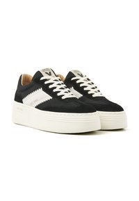 Black suede and mesh sneakers with white accents, flat beige laces, and a thick white sole. Features zigzag design on side panels.