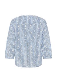 Blouse bleu clair à motifs avec manches longues, présentant un design géométrique blanc et de petits accents noirs, fabriquée en tissu léger.