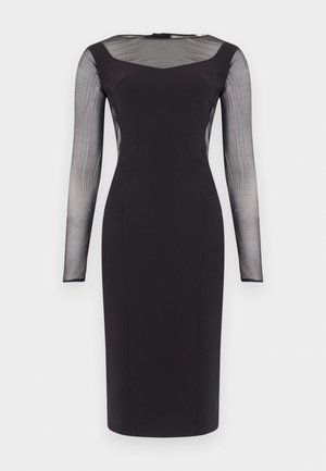 Rochie neagră, cambrată, până la genunchi, cu mâneci lungi din plasă transparentă și panou de plasă la nivelul pieptului superior, decolteu rotund și cusături decorative pe față.