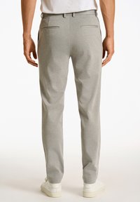 Grijze op maat gemaakte broeken van textuurstof, met twee achterzakken en een slim fit, gecombineerd met witte sneakers.