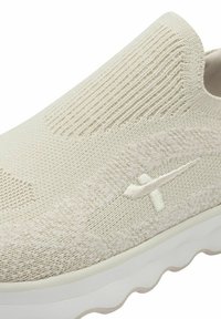 Hellebeige Slipschuhe mit strukturiertem Strick-Obermaterial und weißen Akzenten. Weiches Material, runde Zehenpartie und gepolsterte Sohle mit Wellenmuster.