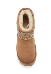 Botín de ante tan con un puño de lana de punto, forro interior suave y suela de goma plana. Diseño de punta redondeada para mayor comodidad.