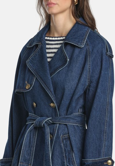 Džínsový trenčkot v hlbokej modrej farbe s opaskom v páse. Má zlaté gombíky, výstrih s výrezom a voľný strih. Vertikálne švové detaily.
