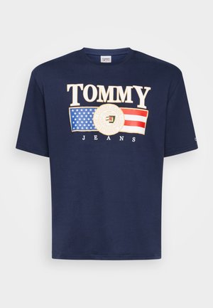 Granatowy T-shirt z dużymi literami "TOMMY", grafiką amerykańskiej flagi, okrągłym logo i nadrukiem "JEANS" poniżej na przodzie.