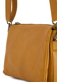 Tan læder crossbody taske med lynlåslukning og prægning af "VENEZIA"-branding, med justerbar rem og metalhardware.