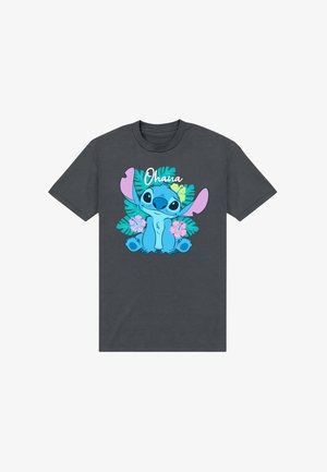 T-shirt gris foncé avec un personnage de dessin animé bleu, grandes oreilles roses, entouré de feuilles vertes et de fleurs roses, avec le mot « Ohana » au-dessus.