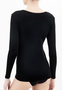 Top lungo nero a maniche lunghe con scollatura rotonda, realizzato in tessuto morbido ed elastico. Presenta una texture liscia e un design aderente.