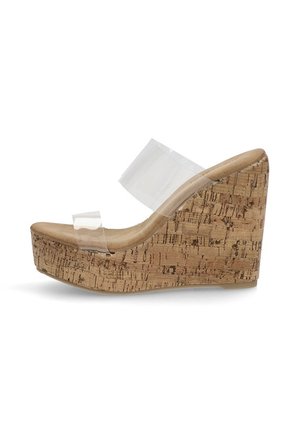 Sandalia de cuña con suela de corcho, tiras de plástico transparente y un tacón moderado. La plantilla es de un suave tono beige.