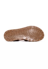 Suela de goma marrón con un patrón de relieve texturizado que presenta ranuras hexagonales y diagonales para un mejor agarre y tracción.