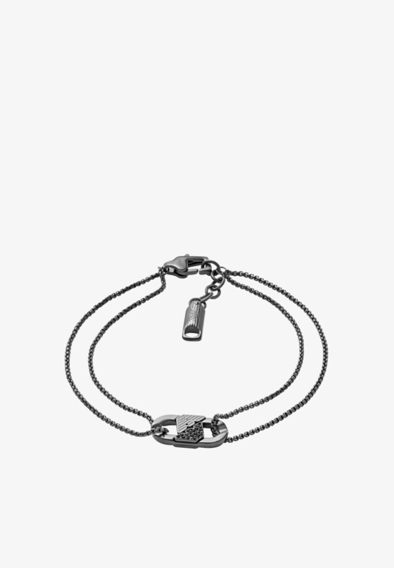 Black metal bracelet featuring two chains, one with a decorative clasp and a textured centerpiece resembling a safety pin.