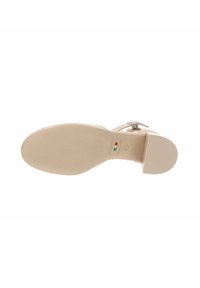 Sandalia de tacón alto beige con textura de cuero suave, punta redondeada, correa ajustable en el tobillo y suela de goma texturizada.