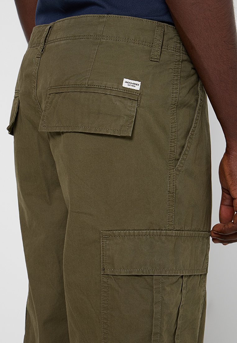 Olivgrüne Cargo-Hose aus Baumwolle. Verfügt über mehrere Taschen und ein gewebtes Etikett auf der Gesäßtasche. Lässige Passform und strukturierter Stoff.