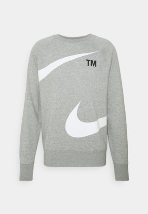 Sweat-shirt gris à manches longues avec grands logos blancs Nike swoosh sur le devant et texte noir "TM" près de l'encolure.