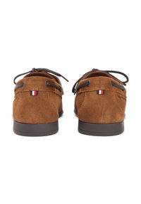 Καφέ σουέτ παπούτσια με στρογγυλεμένο σχεδιασμό, που διαθέτουν καφέ κορδόνια, μικρή τριχρωμία κοντά στη φτέρνα και επίπεδα λαστιχένια πέλματα.