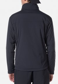 Donkerblauwe geïsoleerde jas met een staande kraag en naadloos ontwerp. Glad textuur en lange mouwen, tailored fit zonder zichtbare logo's.