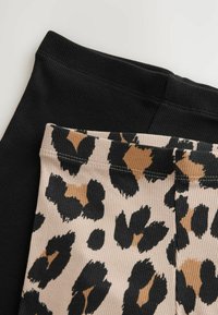 Deux paires de leggings côtelés. L'une est noire uni, l'autre a une base beige avec un motif léopard noir et marron.