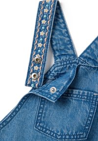Blauwe denim tuinbroeken met geborduurde bloemen- en druppelpatronen op de banden; voorzien van metalen drukknoopsluitingen en een voorzak.