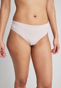 Ljust rosa ribbad bikiniunderdel med en bred midja, i mjuk textur och minimalistisk design. Låg midja med sidona seams.