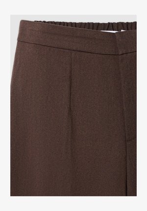 Pantaloni marroni con tessuto testurizzato, dotati di vita sagomata e piega frontale, progettati per una vestibilità slim senza tasche visibili.