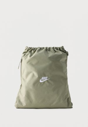 Ανοιχτό πράσινο σακίδιο πλάτης Nike με κορδόνι, με λευκό λογότυπο Nike στο κέντρο μπροστά και κάθετη τσέπη με φερμουάρ στην αριστερή πλευρά.