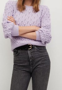 Liliowa sweter dzianinowy z textured wzorem i bufkami, w połączeniu z wysokim stanem ciemnoszarymi dżinsami i czarnym paskiem.
