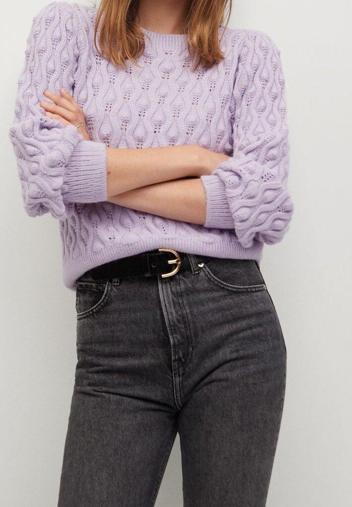 Liliowa sweter dzianinowy z textured wzorem i bufkami, w połączeniu z wysokim stanem ciemnoszarymi dżinsami i czarnym paskiem.