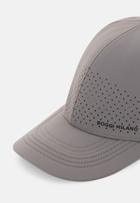 Casquette grise à visière arrondie avec détails perforés et coutures visibles. Logo brodé "BOGGI MILANO" sur le côté.
